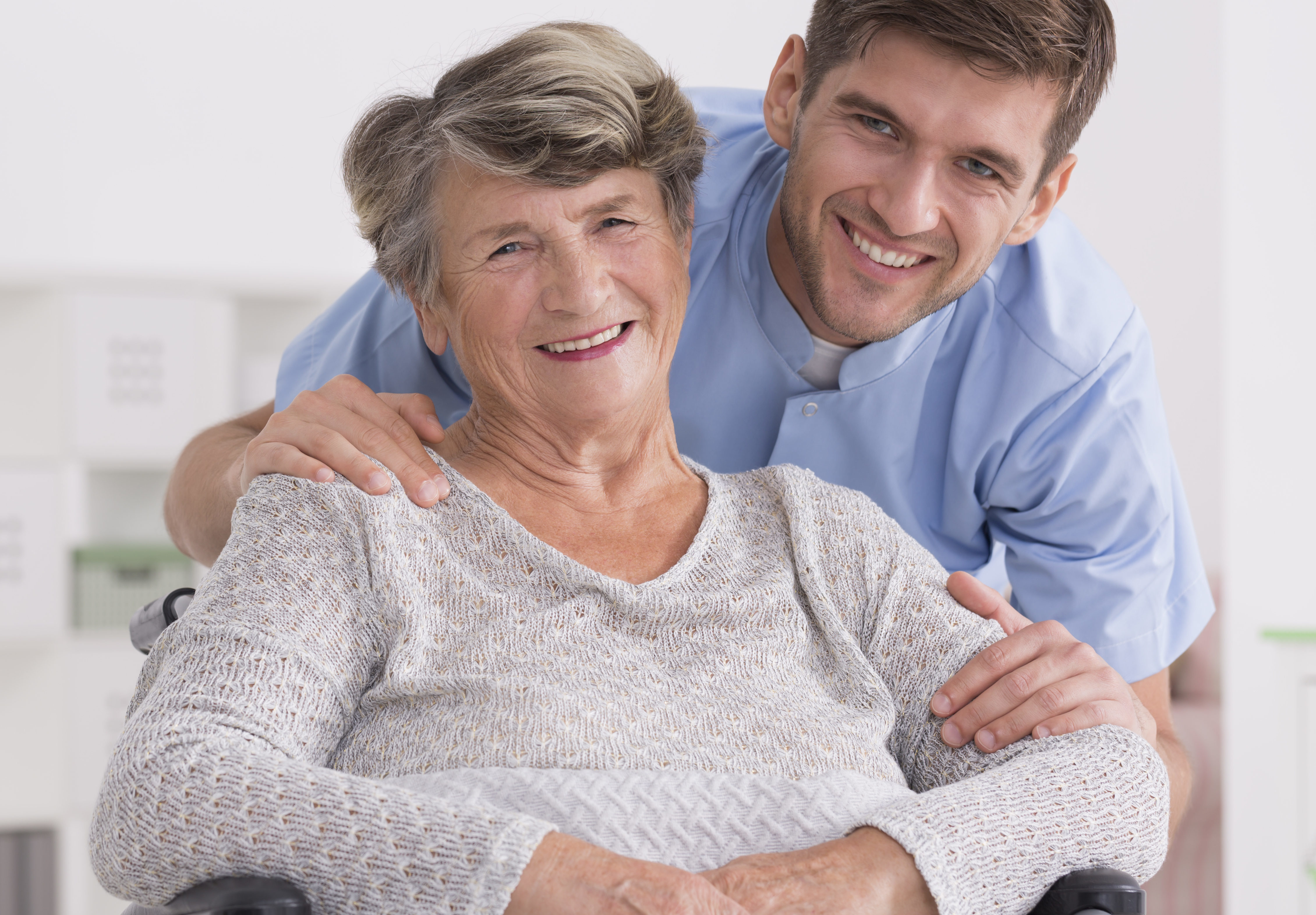 Senior care assistant with disabled woman Senior care assistant with cheerful disabled woman in nursing home