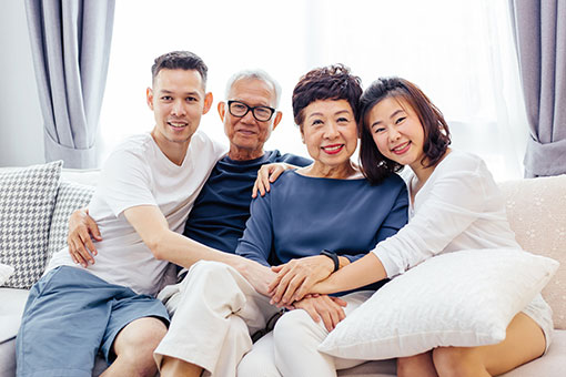 happy asian family on couch protected by medi-cal planning asset protection